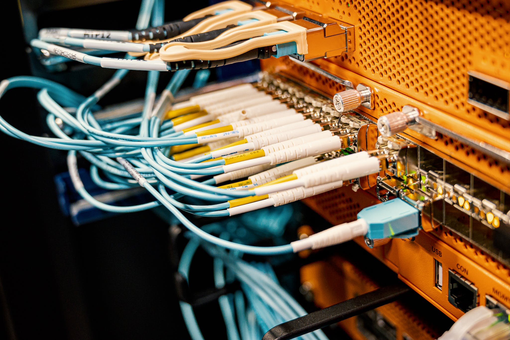 Blue wires connected to contemporary electronic equipment with multiple inputs on blur background